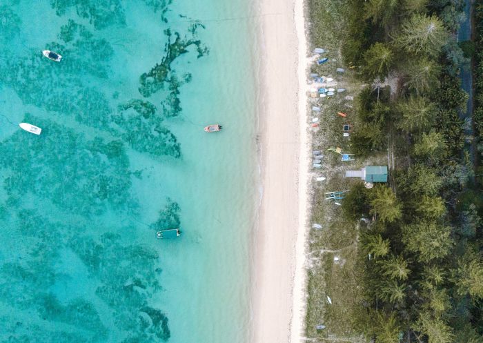 Aerial overlooking boats on the crystal clear waters off The Lagoon Beach, Lord Howe Island