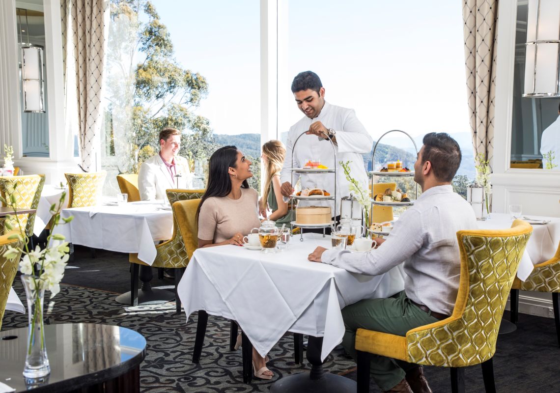 Couple enjoying a premium afternoon high tea at the Wintergarden restaurant within The Hyrdo Majestic Hotel, Medlow Bath