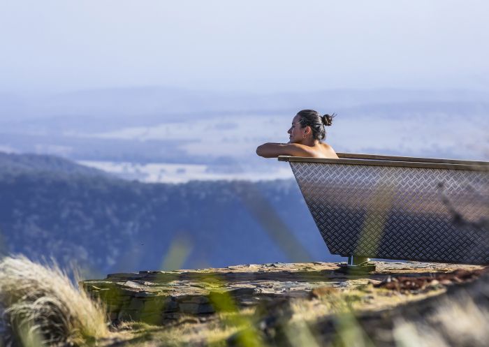 Woman enjoying Bubbletent Australia's outdoor bathtub with scenic views over the Capertee Valley