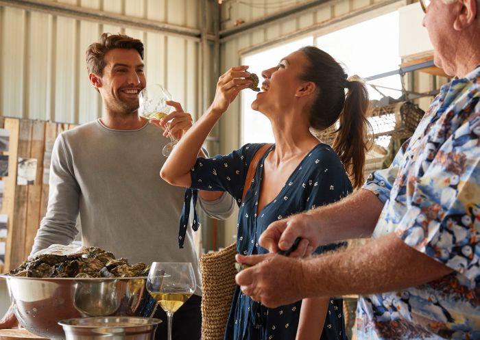 Jim Wild's Oysters in Greenwell Point, Jervis Bay and Shoalhaven Couple enjoying freshly opened oysters with Jim Wild of Jim Wild's Oysters in Greenwell Point, Jervis Bay and Shoalhaven