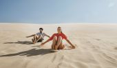 Couple enjoying a sandboarding experience at Stockton Sand Dunes located in the Worimi Conservation Lands